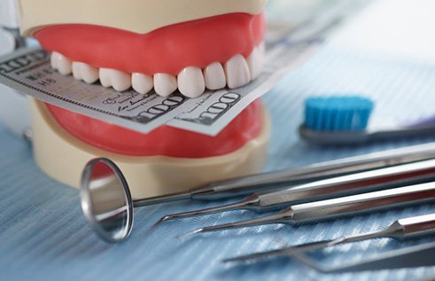 Dental model chomping down on paper money