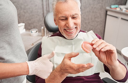 A man examining his wax dentures