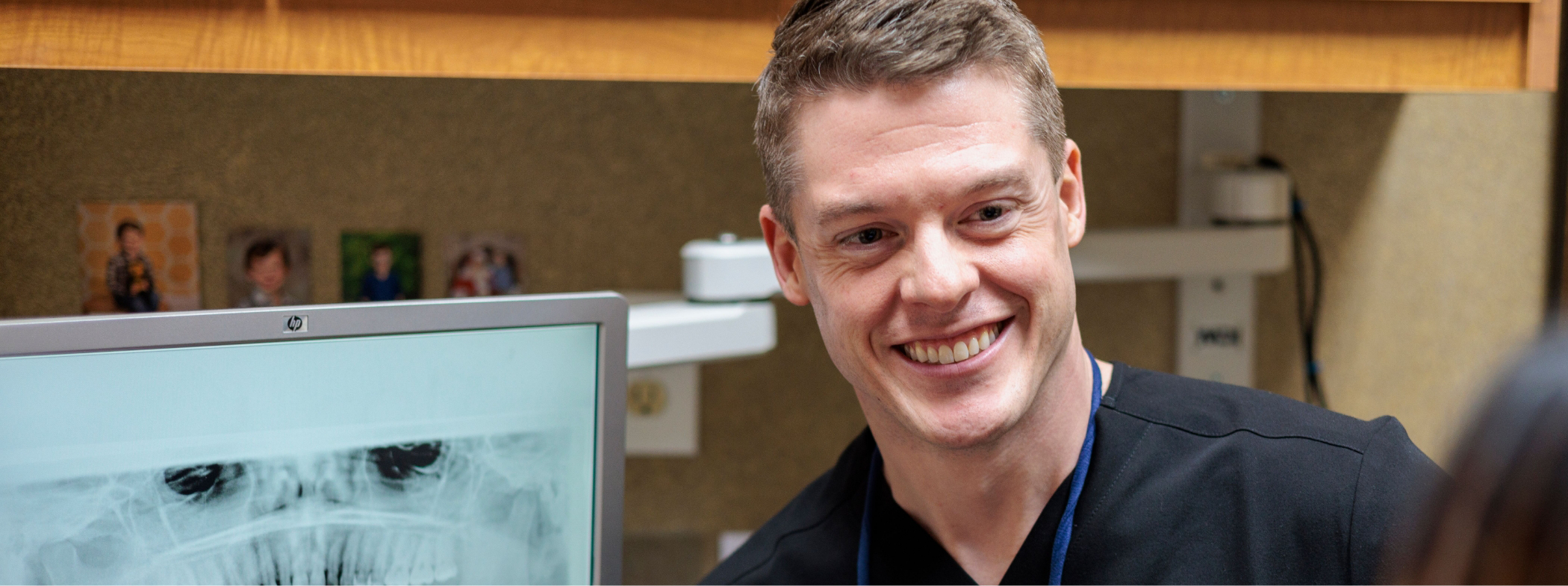 Two dentists looking at x rays of a patients teeth on a computer