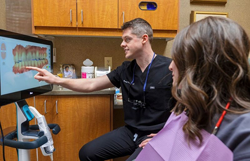 Dentist showing a patient a monitor with digital impressions of their teeth
