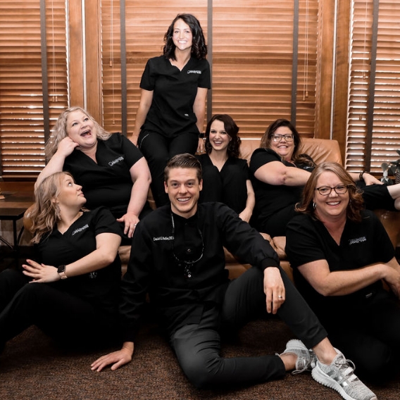 Lillington dentist and team members sitting on and around a couch