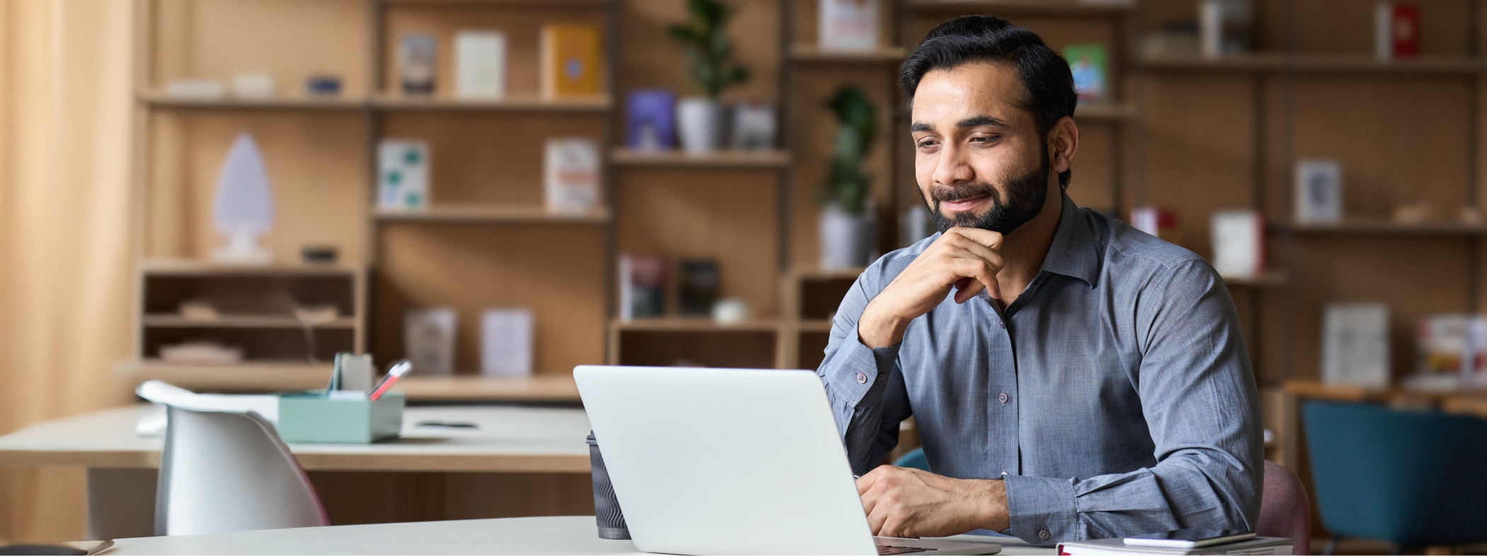 Man sitting at a table and looking at his laptop