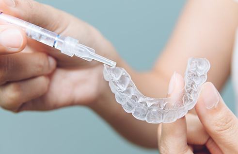 Patient uses teeth whitening kit