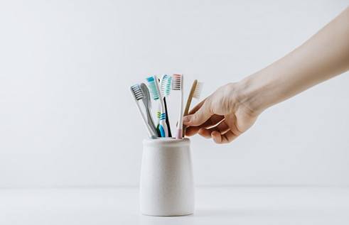 Hand reaches for brush in holder